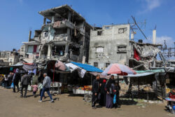 On the market sidewalk… A mother repairs banknotes to resist the siege in Gaza